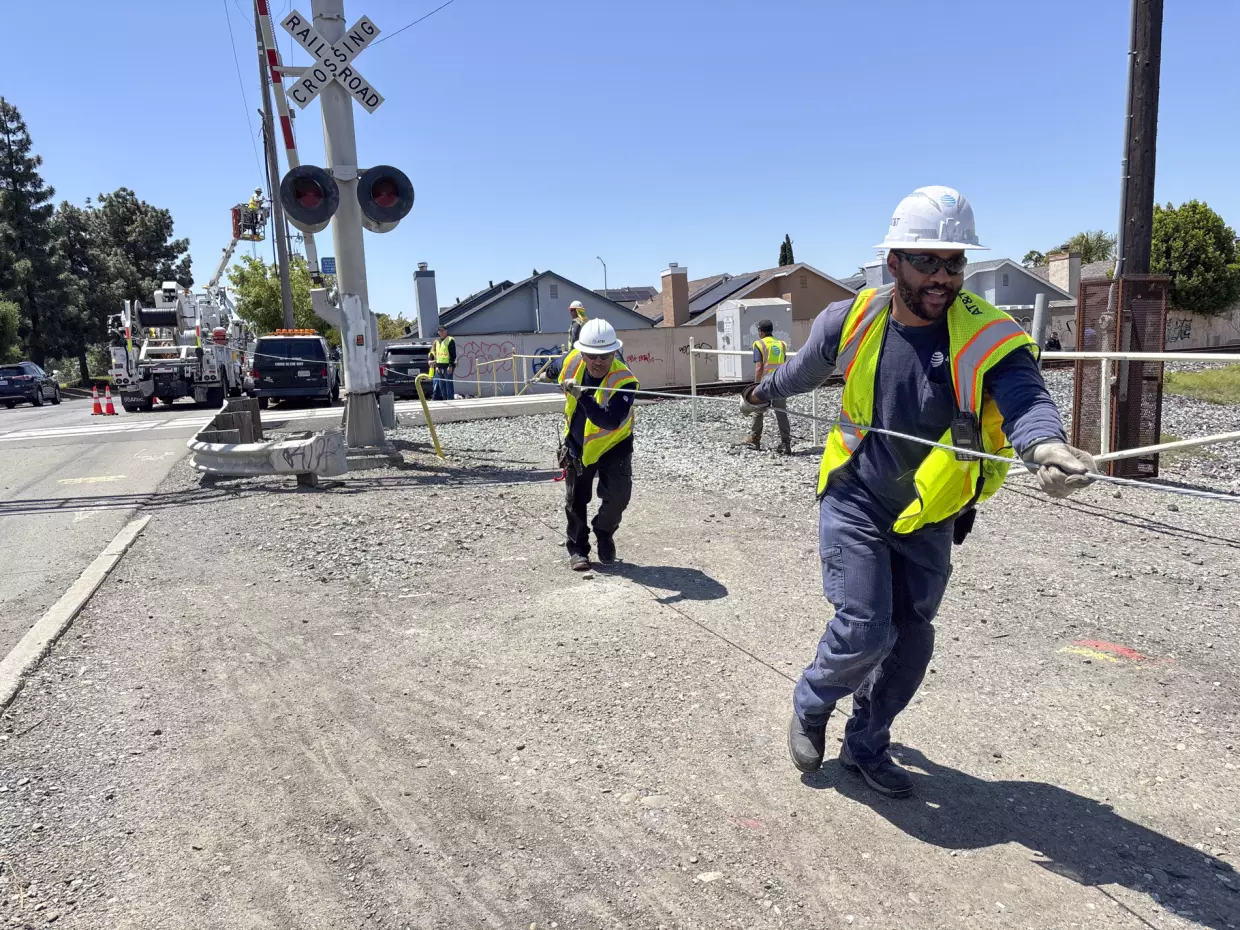 An AT&T crew installs a new cable at a railroad crossing in Hayward, Calif., after the segment got cut down by suspected copper wire thieves.