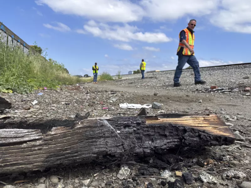 AT&T crew members walk by a "burn pit" near a site where cables were cut.
