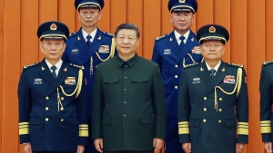 In this photo released by Xinhua News Agency, Chinese President Xi Jinping, also chairman of the Central Military Commission (CMC), front row second from left, poses with other military officers after promoting to generals, back row, from left, Yang Zhibin of the Eastern Theater Command and Han Shengyan commander of Central Theater Command in Beijing on Monday, Dec. 22, 2025.