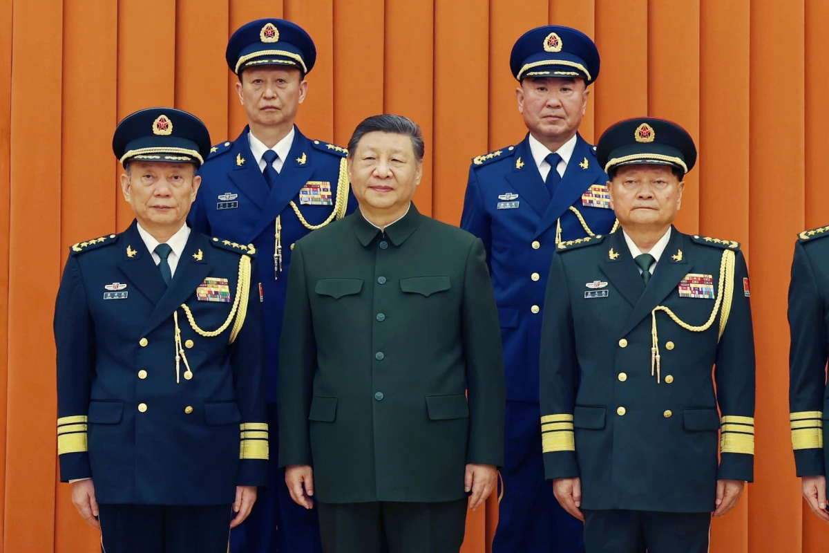 In this photo released by Xinhua News Agency, Chinese President Xi Jinping, also chairman of the Central Military Commission (CMC), front row second from left, poses with other military officers after promoting to generals, back row, from left, Yang Zhibin of the Eastern Theater Command and Han Shengyan commander of Central Theater Command in Beijing on Monday, Dec. 22, 2025.