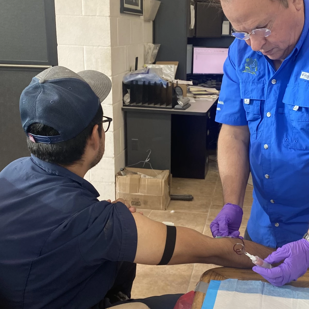 A researcher draws blood from a farmworker to analyze it for signs of a previous bird flu infection.