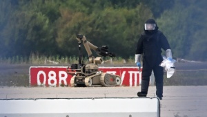 A forensic technician works alongside a bomb-disposal robot near a Ukrainian aircraft at Leipzig/Halle Airport, where a drone with an explosive device was found and a detonator was removed from the object, in Schkeuditz, Germany, Wednesday Aug. 5, 2026.