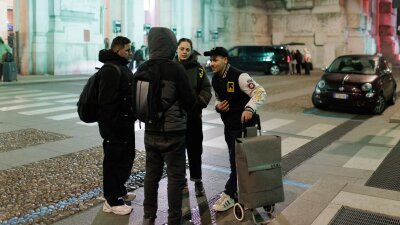 Members of an International Rescue Committee (IRC) outreach team patrol the main hall of Milano Centrale railway station during the night. 