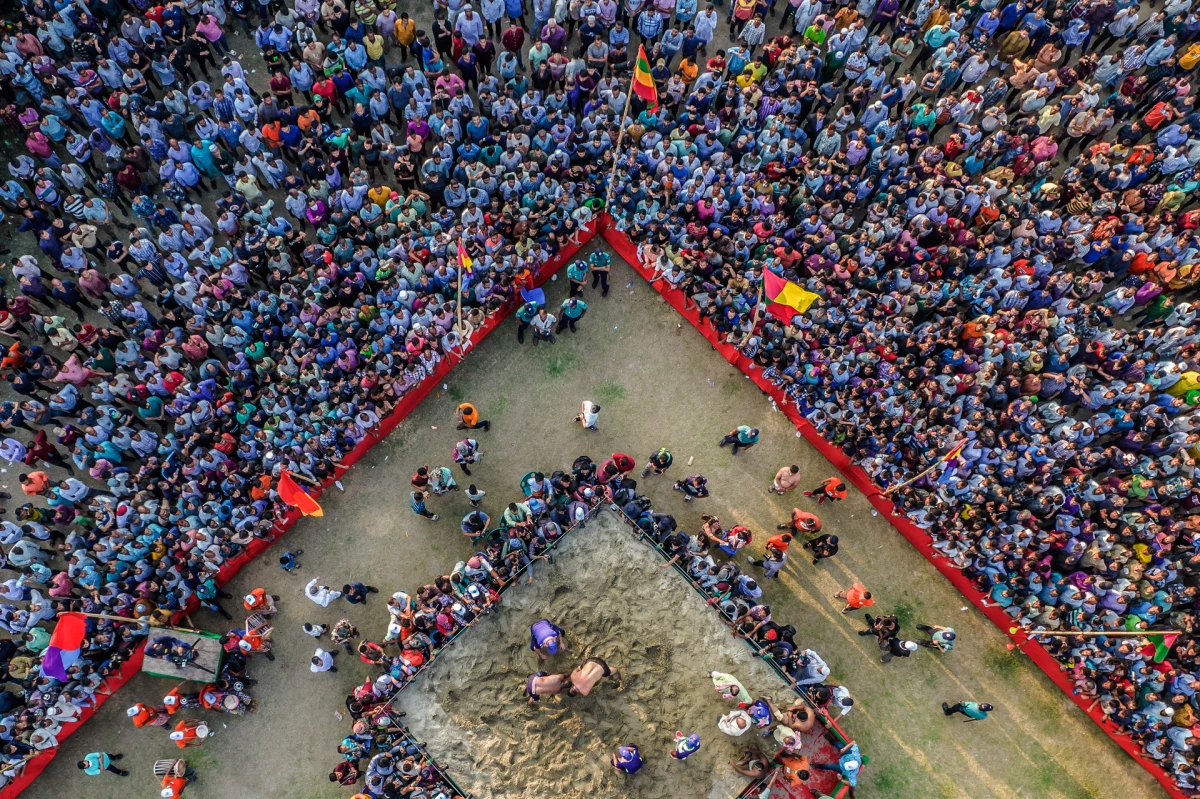 A century-old wrestling competition in Chittagong, Bangladesh, known as Abdul Jabbar's Boli Kheladraws thousands of spectators annually. In this picture from April 24, 2023, two wrestlers go at it on a sandy stage in front of a street audience.