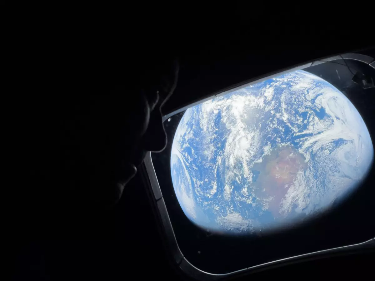 NASA astronaut and Artemis II Commander Reid Wiseman looks at Earth through Orion's main cabin windows as the crew travels towards the moon. Wiseman and his three crewmates are set to return to Earth on Friday.