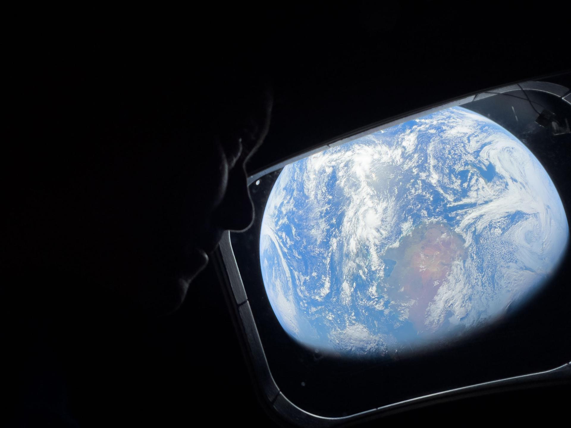 NASA astronaut and Artemis II Commander Reid Wiseman looks at Earth through Orion's main cabin windows as the crew travels towards the moon. Wiseman and his three crewmates are set to return to Earth on Friday. (NASA)