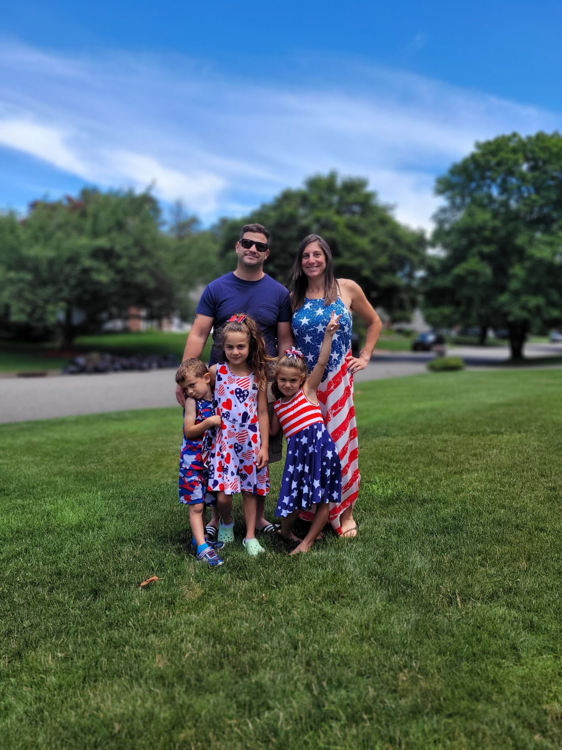 Josiah Mena is seen with his wife and three young children. All five of them are wearing red, white and blue clothings.