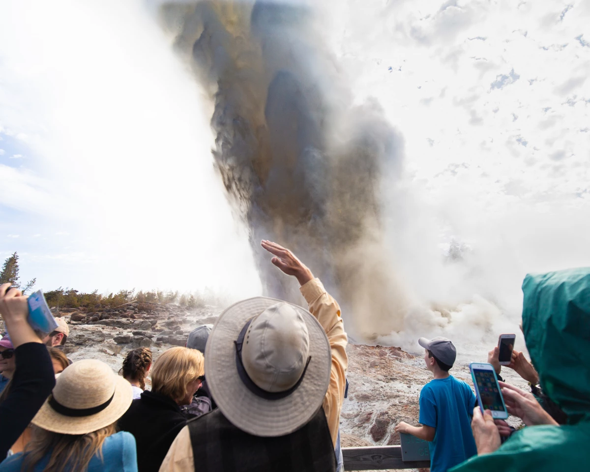 Wyoming, USA - A crowd of people witness the rare eruption of Steamboat Geyser, the largest active geyser in the world.