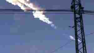 A meteorite contrail is seen in the Chelyabinsk region of Russia on Friday, Feb. 15, 2013 in a photo taken by a mobile phone camera, The meteor streaked across the sky of over the Ural Mountains, causing a shockwave and reportedly injuring hundreds of people, including many who were hurt by broken glass.