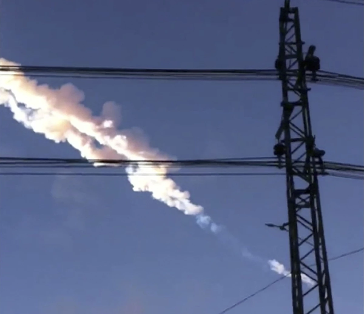 A meteor contrail is seen over Chelyabinsk, Russia on Friday, Feb. 15, 2013, in a photo taken by a mobile phone camera. The object streaked across the sky over Russia's Ural Mountains region causing a shock wave and injuring hundreds of people, including many who were hurt by broken glass.