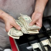 A cashier sorts money at a pizza shop in Miami.