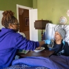 Dawnita Brown gives her mother, Joan Cain, water to help swallow pills after breakfast. Brown is the primary caregiver to her mother and father.