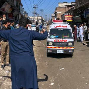 A volunteer clears the way for an ambulance transporting injured school children following a roof collapse at a private school in Peshawar, Pakistan, Thursday, Oct. 15, 2026.