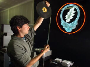 David Lemieux, audiovisual archivist for the Grateful Dead, holds up a piece of 16 mm motion picture film while working at the band's warehouse in Novato, Calif., on Aug. 7, 2000. Despite the band's breakup after leader Jerry Garcia's death in 1995, Grateful Dead Productions runs a multimillion-dollar business from the warehouse in paraphernalia and other merchandise. The Dead's most recognizable emblem, the