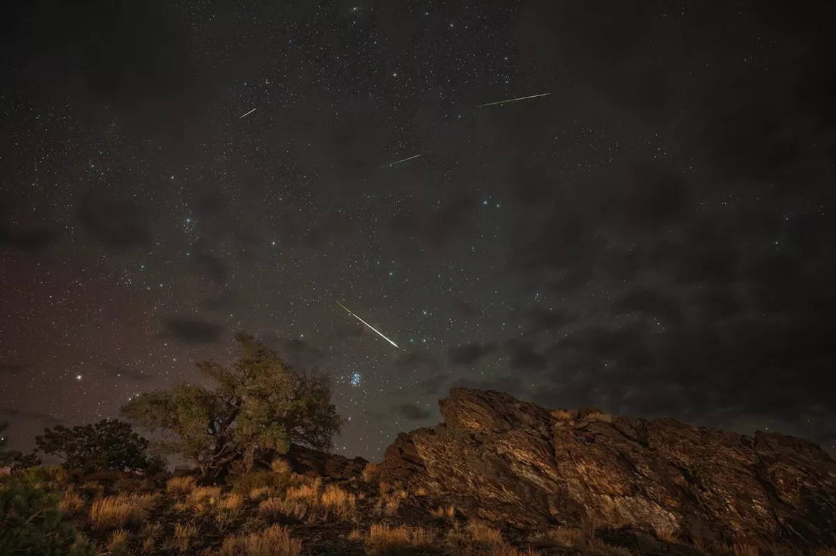 Meteors from the Perseids Meteor Shower streak across a partly cloudy sky above Inyo National Forest in Bishop, California, in 2024.