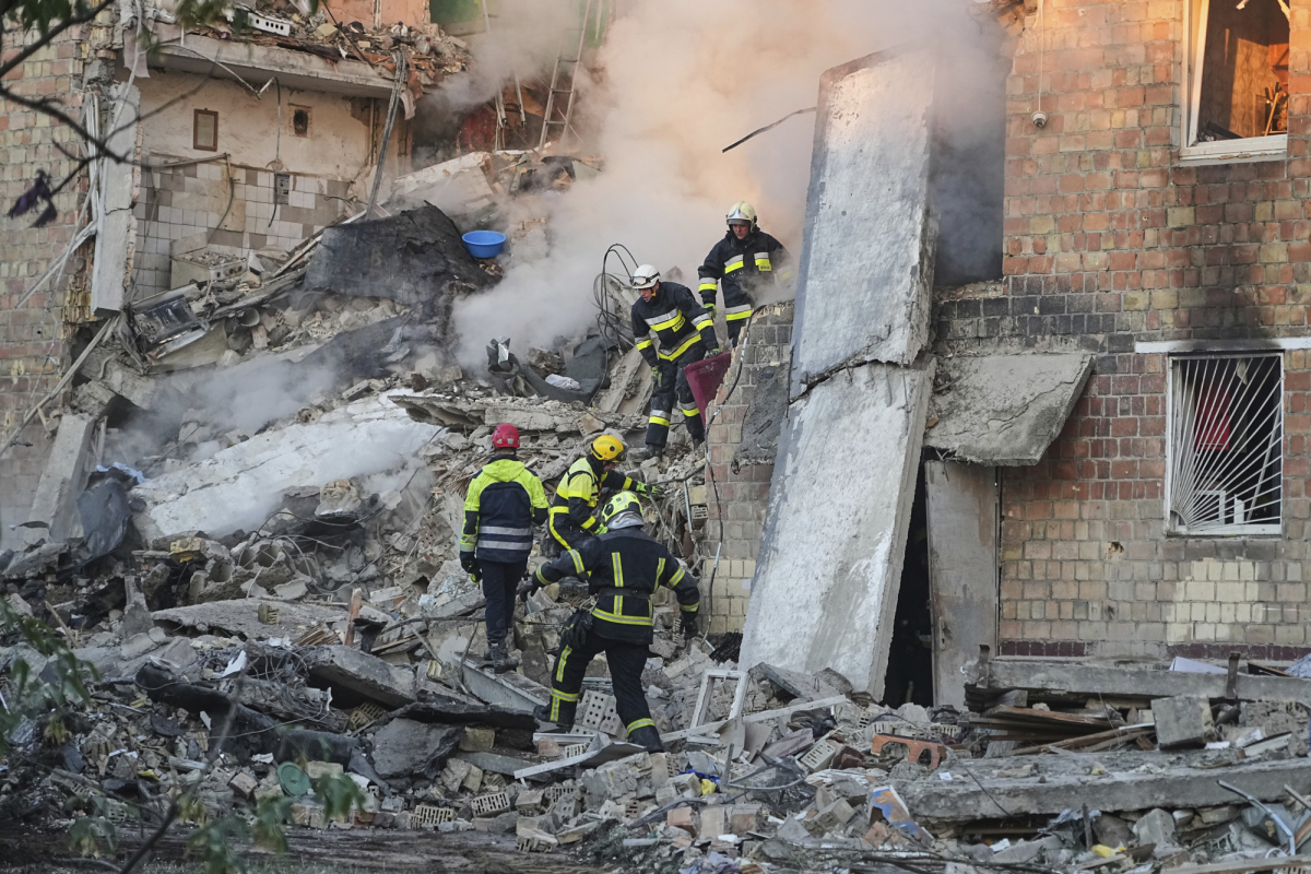 Firefighters work on the site of a burning building after a Russian attack in Kyiv, Ukraine, early Thursday.