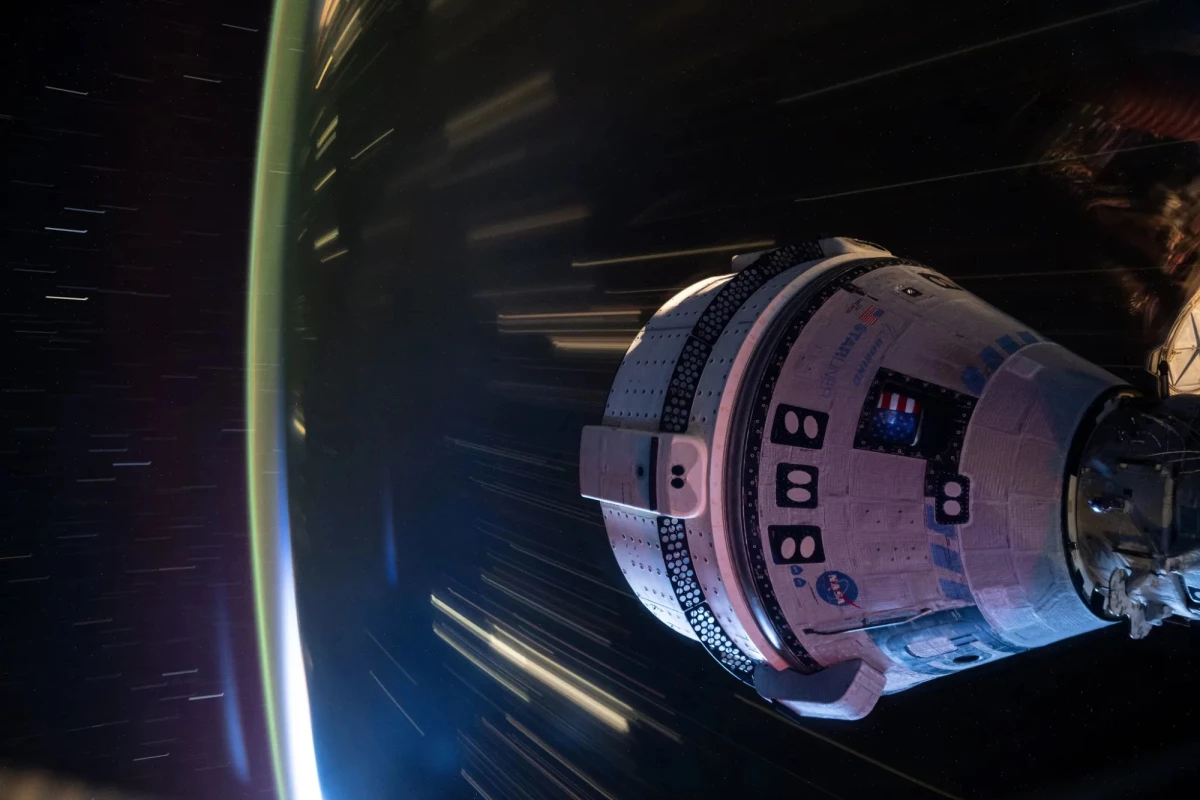 This long-duration photo shows Boeing’s Starliner docked to the International Space Station at night, with the Earth whizzing by below.