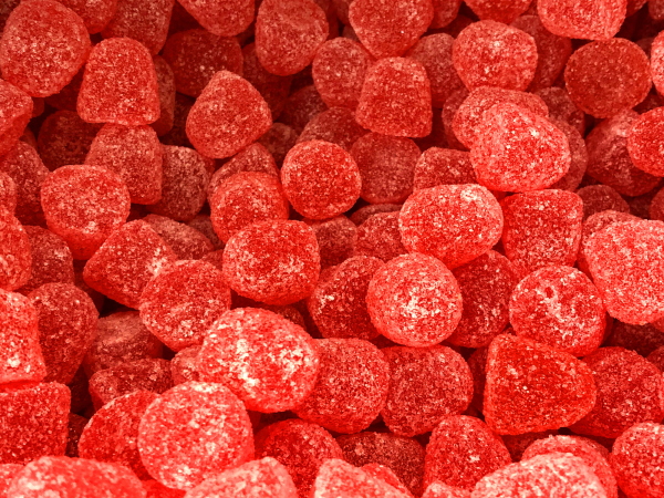 Stock photo of sweet shop pic and mix display of sugar coated red jelly sweet / gummy drops.