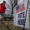 A voter walks past a sign that reads