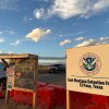 Entrance to Camp East Montana in El Paso, Texas. Image show a white DHS sign and orange barricades on the ground. 