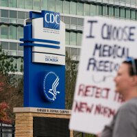 Протестующие против масок, вакцин и паспортов вакцин маршируют возле штаб-квартиры Центров по контролю и профилактике заболеваний в Атланте в 2021 году.