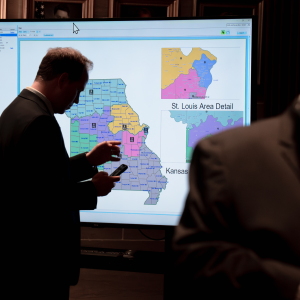 Onlookers gather around a large screen displaying Missouri congressional maps during an extraordinary legislative session Monday, Sept. 8, 2025, at the Capitol in Jefferson City, Mo.