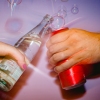 A close-up photo shows people holding fizzy water and a soda, while cheering with one another in front of a purple backdrop with bubbles.