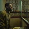 Lupita Nyong’o as Samira looking at a reflection of herself in the mirror. 