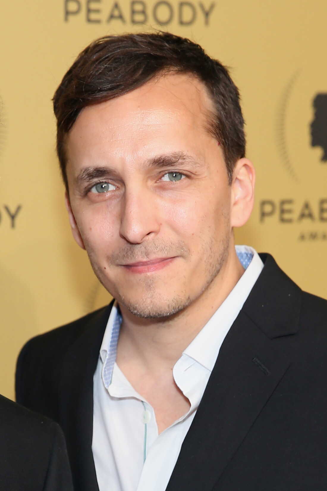 Brent Renaud is photographed at the Peabody Awards ceremony in 2015. A backdrop behind him says "Peabody" on it.