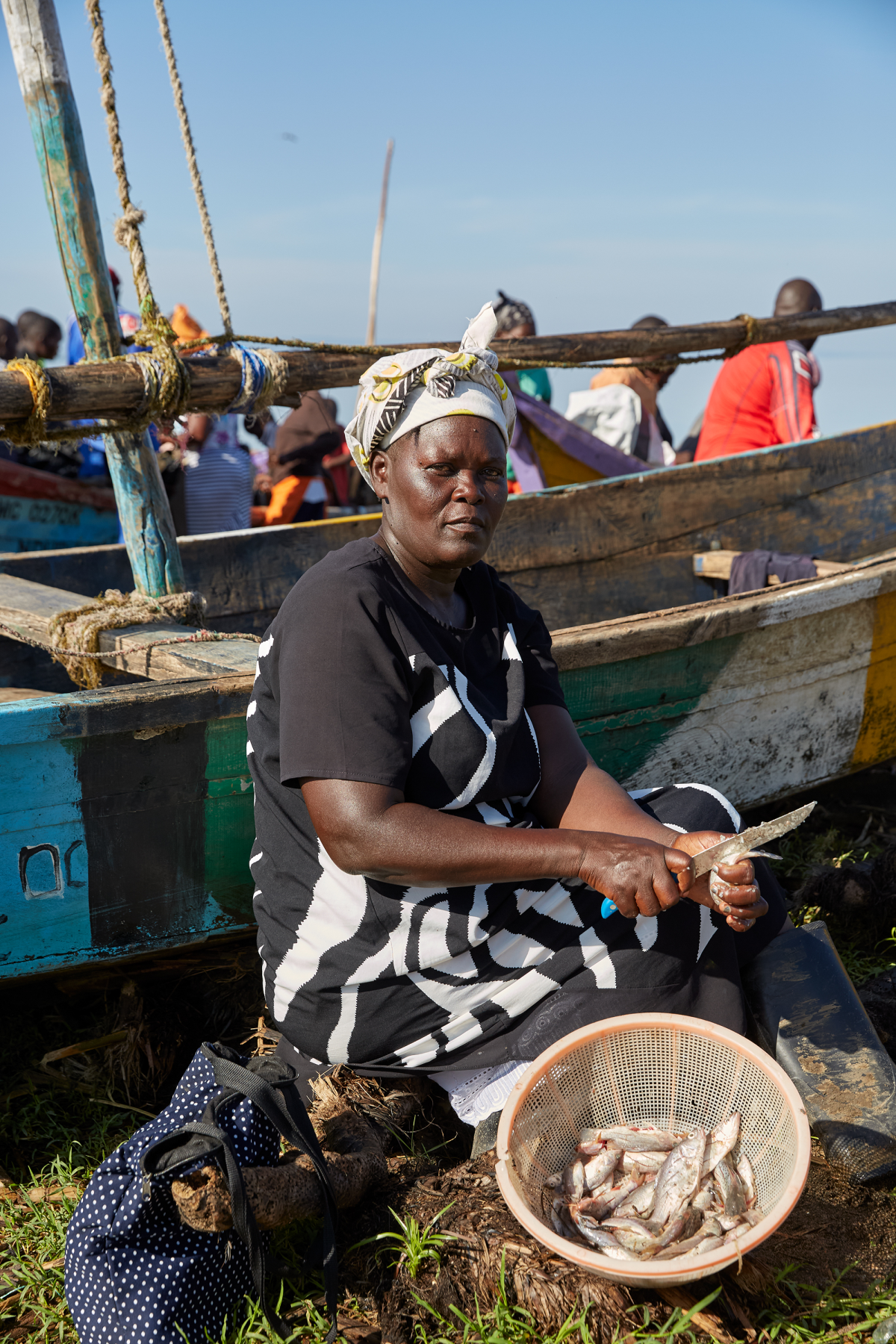 Rebbeccah Atieno, a No Sex For Fish member, scales and guts the fish she bought from fellow member Alice Akinyi at Nduru Beach, getting them ready to sell.