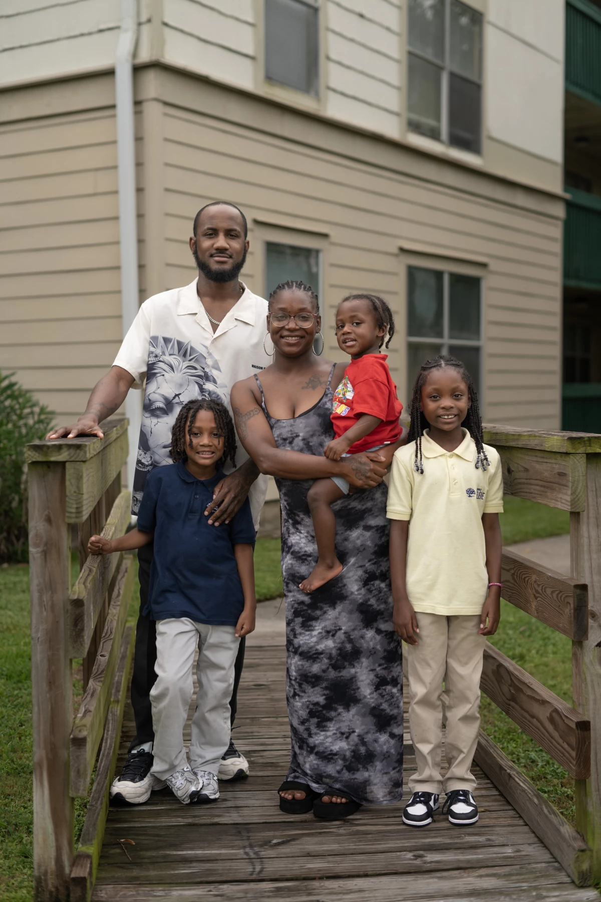 Geraldlynn Stewart (center) poses for a portrait outside her apartment complex with partner Will Porche, and her three children: Harlem, 6; Harvee', 2; and Harmony, 8.