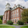 This photo shows a multistory, older-style brick building with a mansard roof on a former college campus in Montpelier, Vermont.