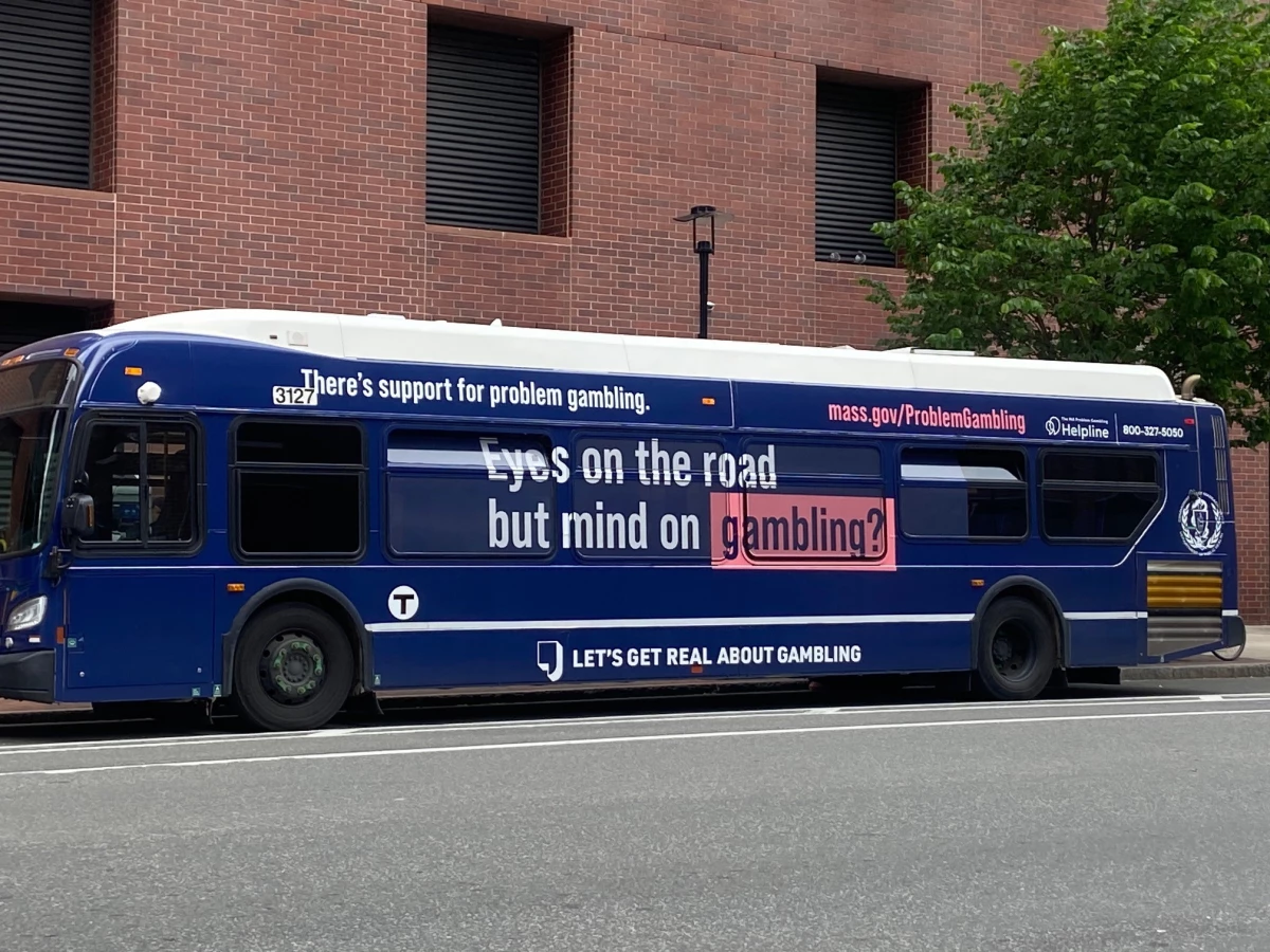 A bus in Boston displays a public service announcement based on the 'responsible gaming' model.