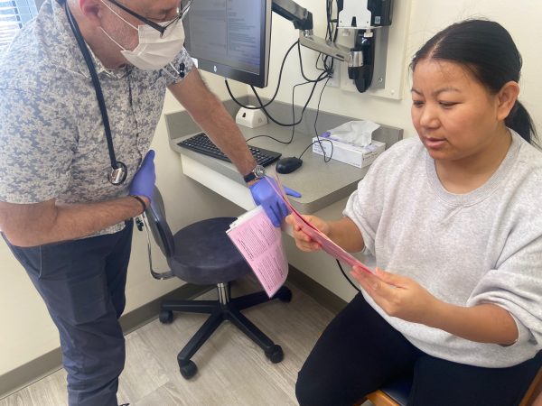 Pediatrician John Snyder gives vaccine information to Tenzin Dekey, who had brought her 1-year-old son to Amherst Pediatrics for an annual exam. She accepted the vaccines that Snyder recommended.