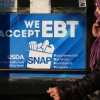 A SNAP EBT information sign is displayed at a bakery as a woman walks past in Chicago, Nov. 2.