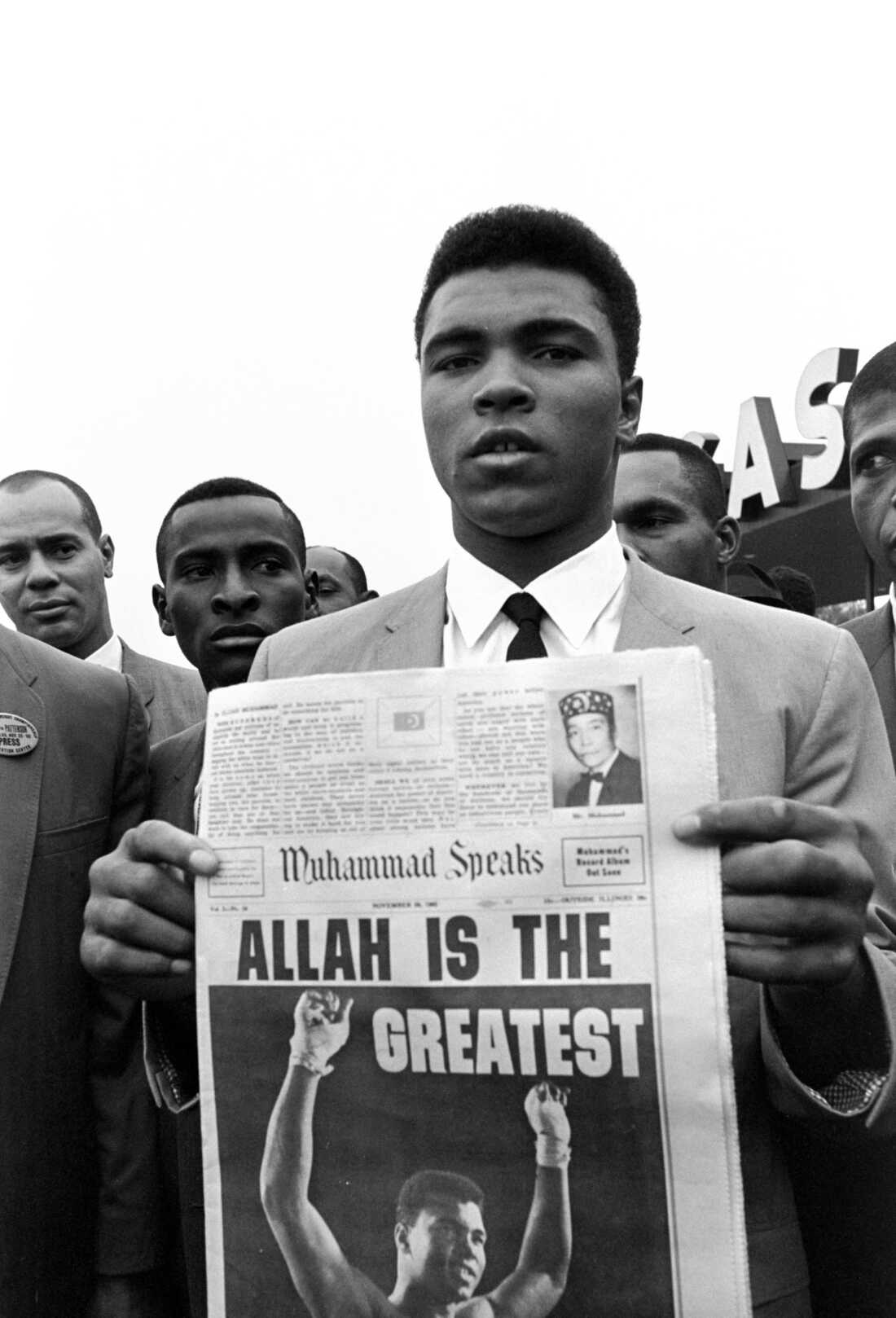 In this Nov. 22, 1965 file photo, heavyweight champion Muhammad Ali holds a "Muhammad Speaks" newspaper bearing his picture as he and followers of the Nation of Islam leave the Las Vegas convention center after weigh-in ceremonies to defend his title against challenger Floyd Patterson.