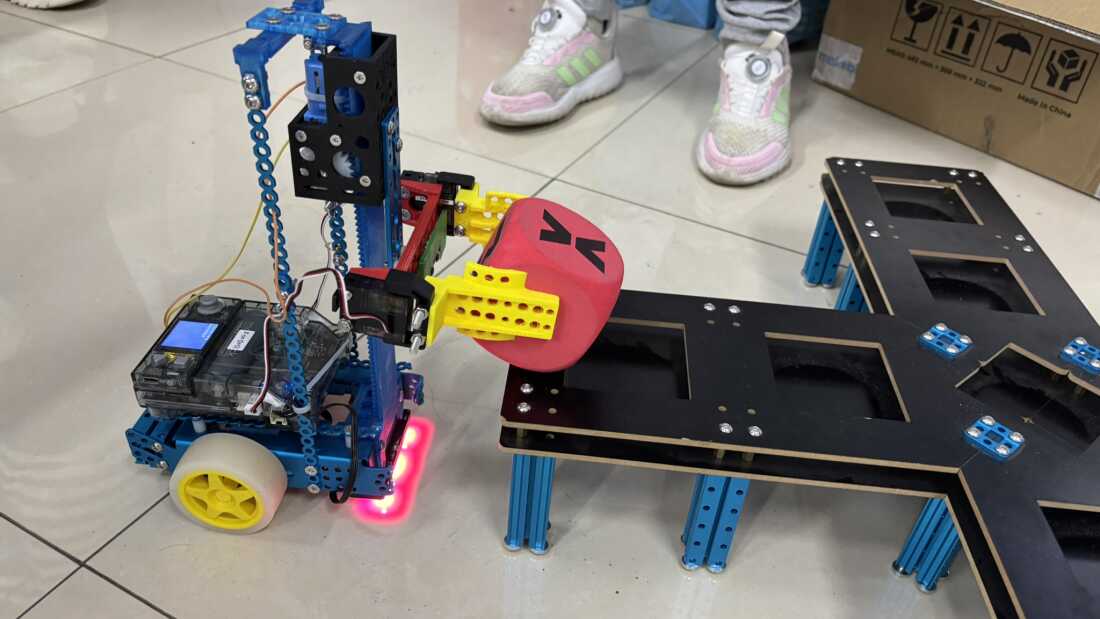 A robot lifts a cube in an elementary school in classroom in Beijing.