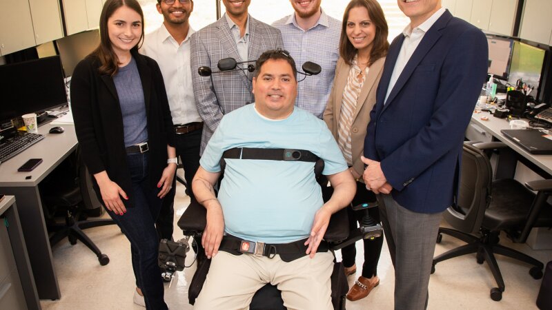 Keith Thomas, who lives with paralysis, poses with the research team at Northwell Health’s Feinstein Institutes for Medical Research that worked with him for months to restore lasting movement and feeling in his arm and hand. The first-of-its-kind ‘double neural bypass’ system uses brain implants and artificial intelligence to allow signals to and from Thomas’ brain to bypass the site of his injury.