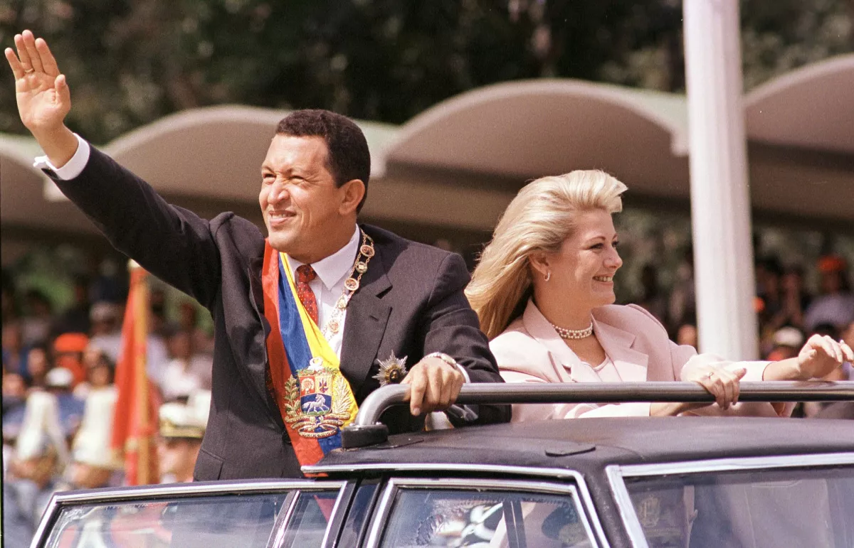 Then-Venezuelan President Hugo Chávez, accompanied by his wife Marisabel Rodríguez de Chávez, waves to supporters as he arrives to preside over a parade in his honor on Feb. 4, 1999. Hugo Chávez died in 2013.