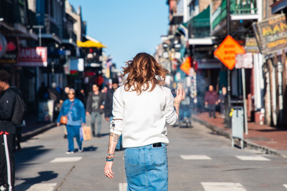 A woman walks down Bourbon Street while burning sage to cleanse the area following the attack. (WWNO)