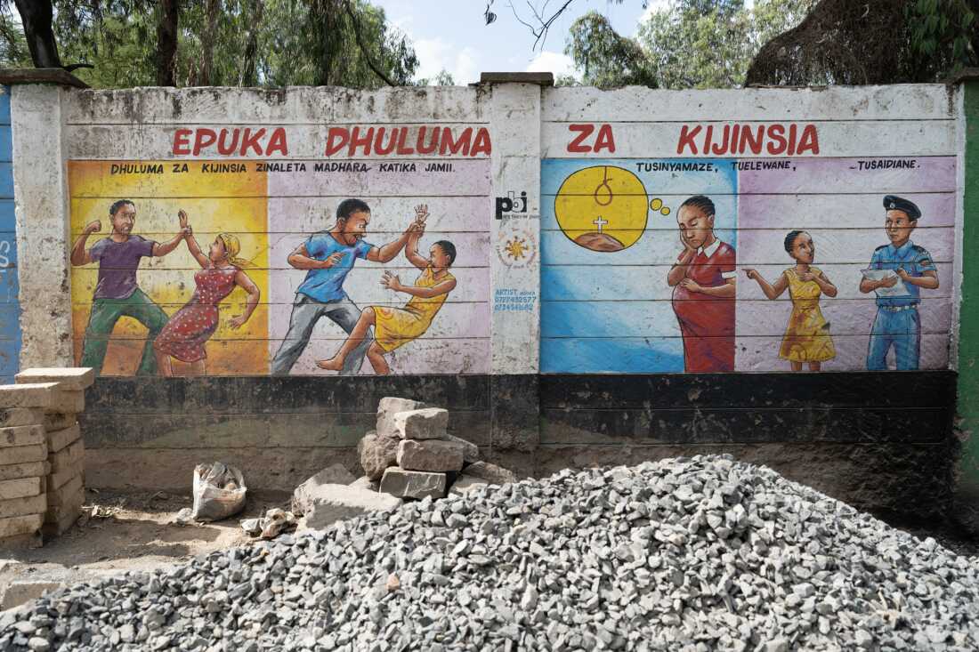 A mural on a wall encourages women and girls to report sexual harassment or assault.