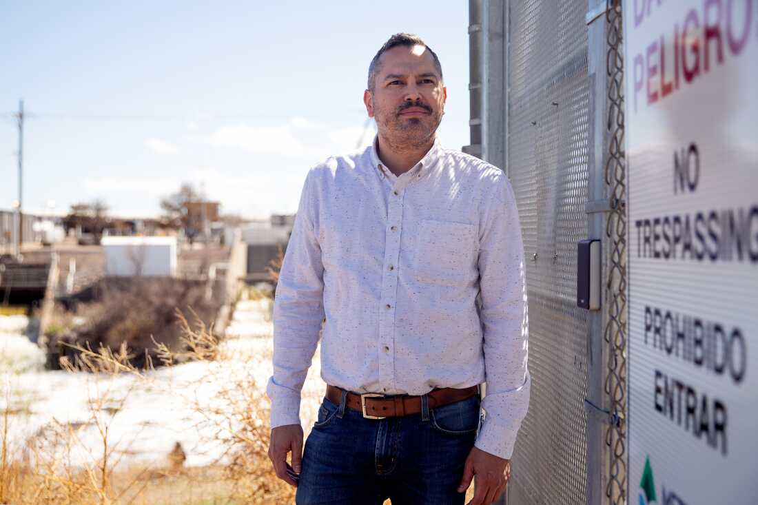 Daniel Freedman stands next to a metal fence at Metro Water Recovery’s treatment facility along the South Platte River in Denver. The facility is in the background.