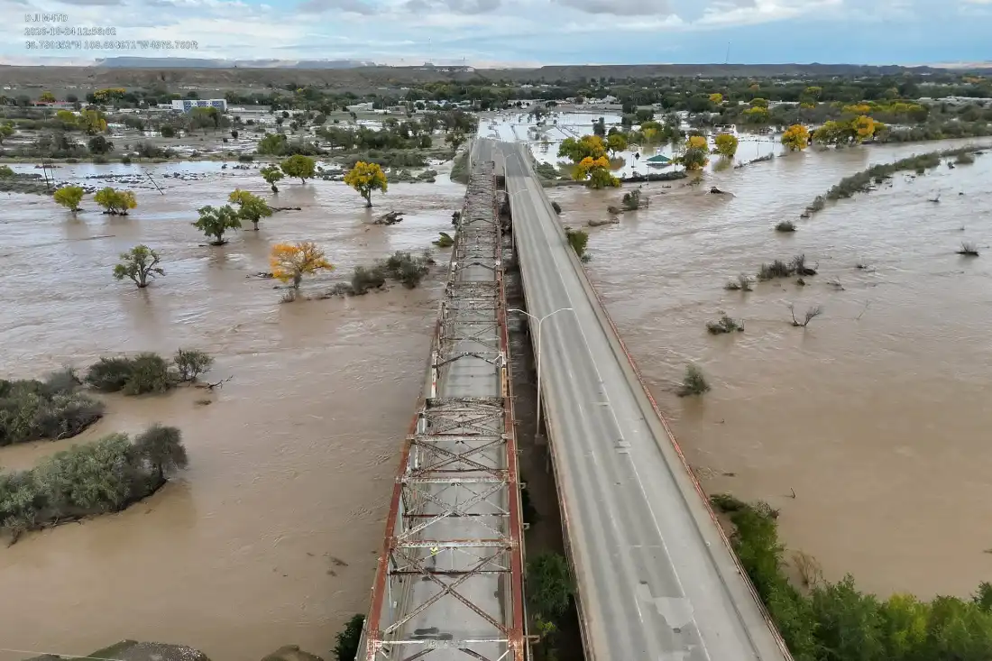 An aerial image Shiprock Bridge spanning over a flooding San Juan River.