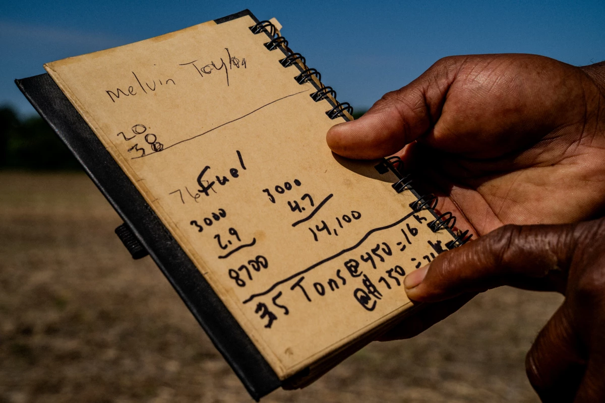 Anthony Bland holds a notebook he's used to calculate diesel fuel and fertilizer price increases, which have spiked due to the closure of the Strait of Hormuz.