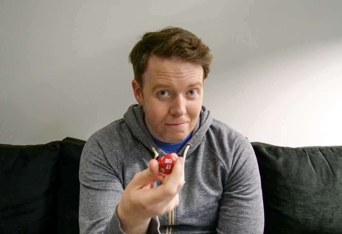 Brennan Lee Mulligan holding a 20-sided die backstage at Climate Pledge Arena in Seattle after Dimension 20's performance there in July of 2025.