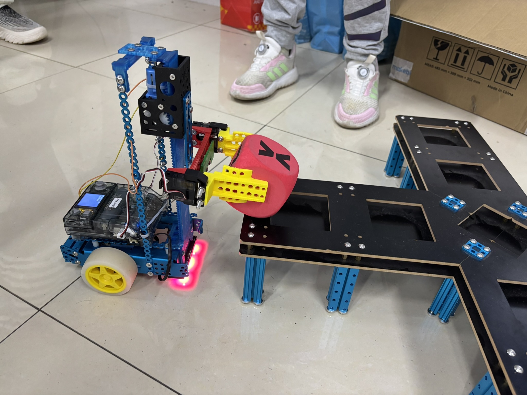 Li Zichen, a fifth grader at a Chinese public school, demonstrates a remote-controlled robot that can lift and move blocks and be programmed using artificial intelligence. (NPR)