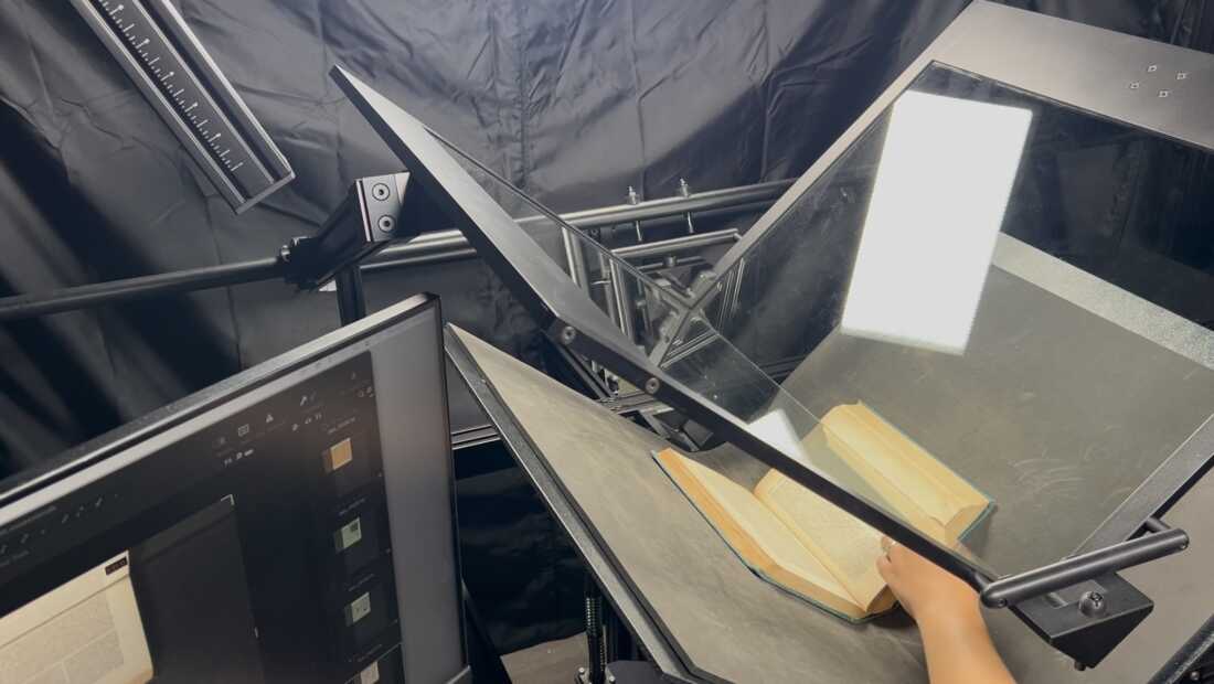 A book undergoing the digitization process in a scanner at Boston Public Library.