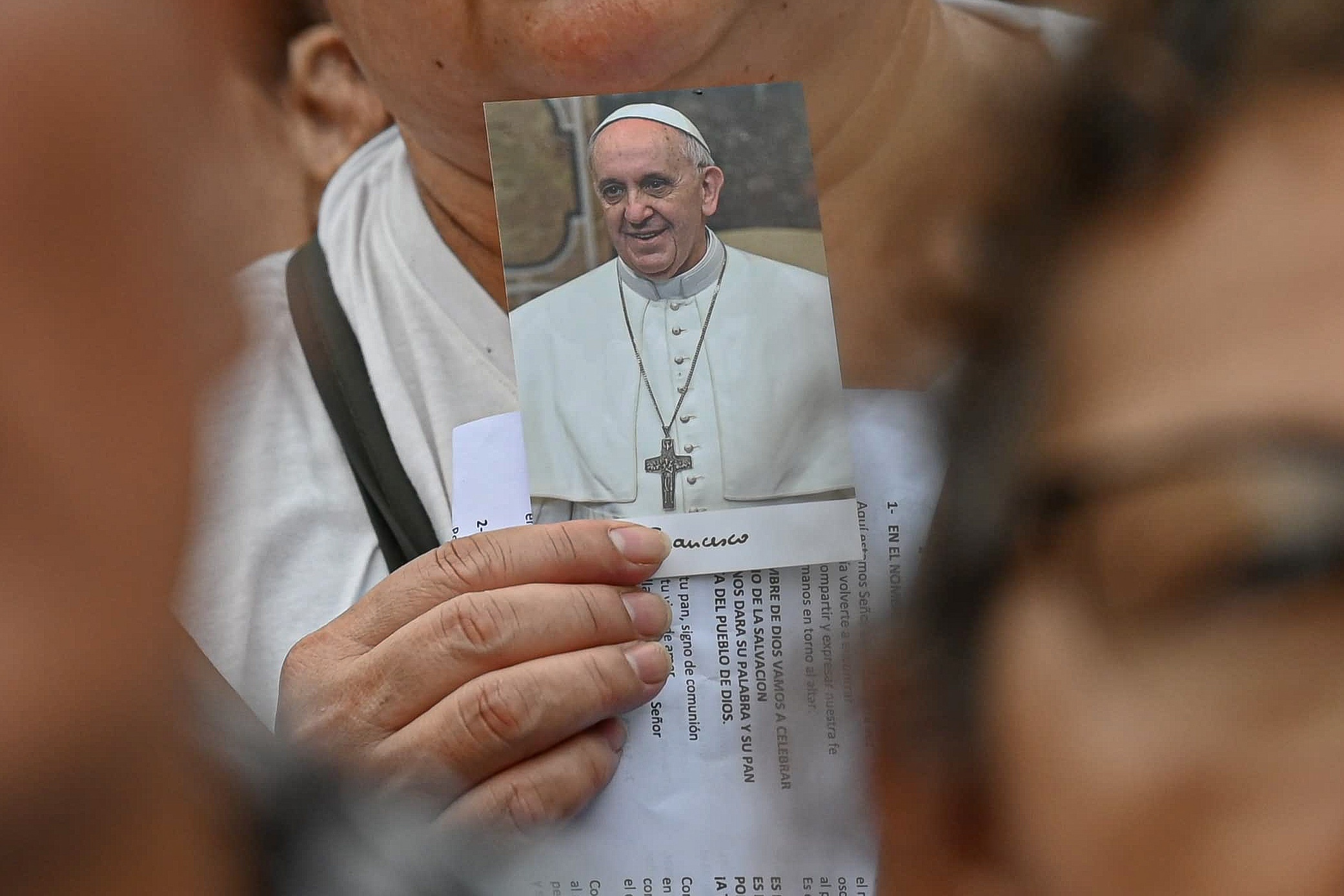 A worshipper carries a picture of Pope Francis as large crowds gather for Mass, led by Archbishop Jorge García Cuerva of Buenos Aires, to pray for the health of Pope Francis, in Buenos Aires, Argentina, Monday.