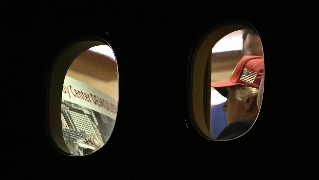 President Donald Trump is seen aboard Air Force One looking at a large Kennedy Center printout after landing in Maryland on Wednesday.