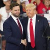 Former President Trump and his running mate, Sen. JD Vance of Ohio, shake hands at a campaign rally at Georgia State University in Atlanta, on Aug. 3, 2024.